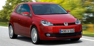 En röd Volkswagen Polo kör nerför en väg. (AI text)