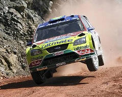 En rallybil kör nerför en grusväg. (AI text)