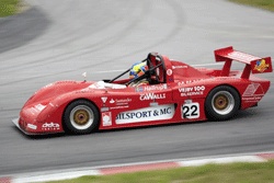 En röd racerbil kör längs banan. (AI text)