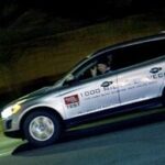 En Volvo XC90 kör nedför gatan på natten. (AI text)