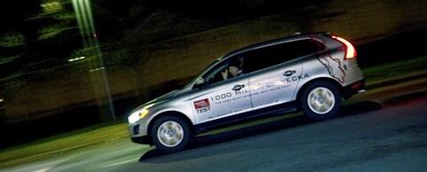 En Volvo XC90 kör nedför gatan på natten. (AI text)