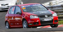 En röd Volkswagen Golf GTI kör på en racebana. (AI text)