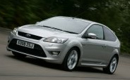 En silverfärgad Ford Focus ST kör nedför en väg. (AI text)