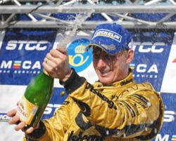 En raceförare firar med en flaska champagne. (AI text)