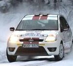 En Ford Fiesta rallybil kör genom snö. (AI text)