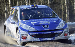 En rallybil kör på en snöig väg. (AI text)