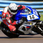 en racerbilförare på en motorcykel på en racerbana (AI text)