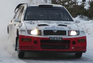 En rallybil kör genom snö. (AI text)