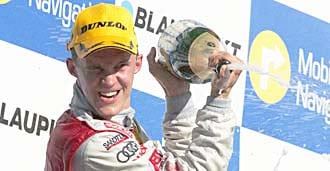 En racerförare firar efter att ha vunnit Audi A3-mästerskapet. (AI text)