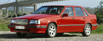 En röd Volvo S40 parkerad på en grusväg. (AI text)