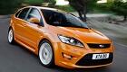 En orange Ford Focus ST kör nerför en väg. (AI text)