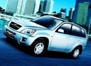 En Suzuki XVS-T SUV kör på en stadsgata. (AI text)