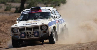 En rallybil kör nerför en grusväg. (AI text)