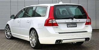 En vit Volvo V70 vagn parkerad framför en garage. (AI text)