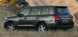 En grå Toyota Land Cruiser parkerad på en gräsmatta. (AI text)