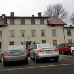 En grupp bilar parkerade framför ett hus. (AI text)