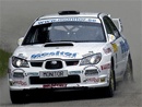 En vit Subaru-rallybil kör nerför en backe. (AI text)