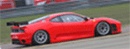 En röd Ferrari F12tdf tävlingsbil på en bana. (AI text)
