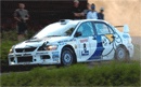 En rallybil kör nedför en grusväg. (AI text)