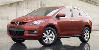 En röd Mazda CX-9 SUV parkerad på en blöt gata. (AI text)