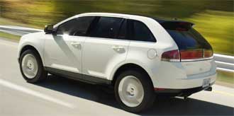 En vit bil kör nerför en väg. (AI text)