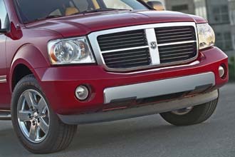 En röd Dodge Ram SRT-utanlastigt fordon parkerad framför ett byggnad. (AI text)