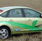 En grön Ford Focus parkerad i en åker. (AI text)