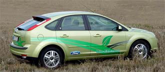 En grön Ford Focus parkerad i en åker. (AI text)