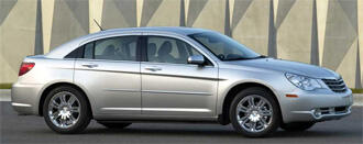 En silver Chrysler Saturn parkerad framför ett byggnad. (AI text)