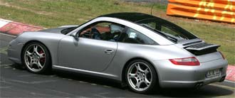 En silverfärgad Porsche 911 GTS kör på en racerbana. (AI text)
