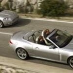 Två silver Jaguar XKR cabriolet kör nedför en bergsväg. (AI text)