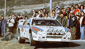 En rallybil står parkerad framför en skara människor. (AI text)