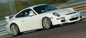 En vit Porsche 911 GT3 kör på banan. (AI text)