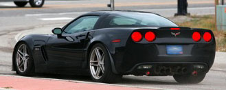 En svart Chevrolet Corvette C7-sportsbil kör ner på gatan. (AI text)