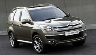 En grå Citroën C3 parkerad framför en byggnad. (AI text)