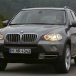 BMW X5-terrängbil kör nedför en landsväg (AI text)