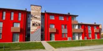 En röd lägenhetsbyggnad med rött tak (AI text)