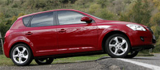 En röd Chevrolet Saturn S-Max parkerad vid en gata. (AI text)