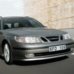 En silverfärgad bil kör nerför en väg. (AI text)