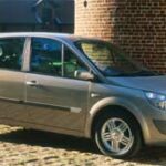 En silverfärgad bil parkerad på en murad väg. (AI text)