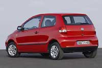 En röd Volkswagen Polo parkerad vid gatan. (AI text)