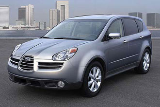 En silverfärgad SUV parkerad framför en stad. (AI text)