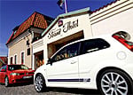 Bilar parkerade framför ett hotell. (AI text)