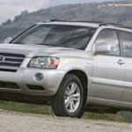 En silver Toyota Highlander parkerad på en grusväg. (AI text)