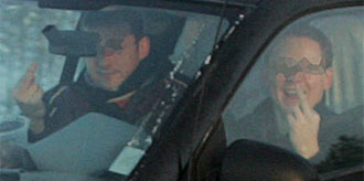 En man sitter i en bil bredvid en kvinna i passagerarsätet. (AI text)