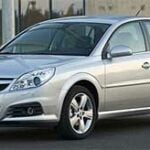 En silverfärgad bil står parkerad framför ett byggnad. (AI text)