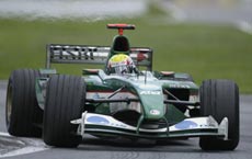 En grön Formel 1-bil körs längs banan. (AI text)