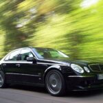 En Mercedes-Benz E-klass kör på en landsväg. (AI text)