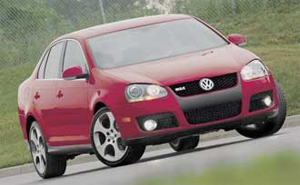 En röd Volkswagen Jetta kör nerför en väg. (AI text)