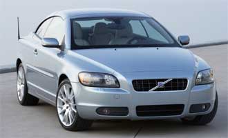 En silverfärgad Volvo S60 coupé parkerad vid en gata. (AI text)